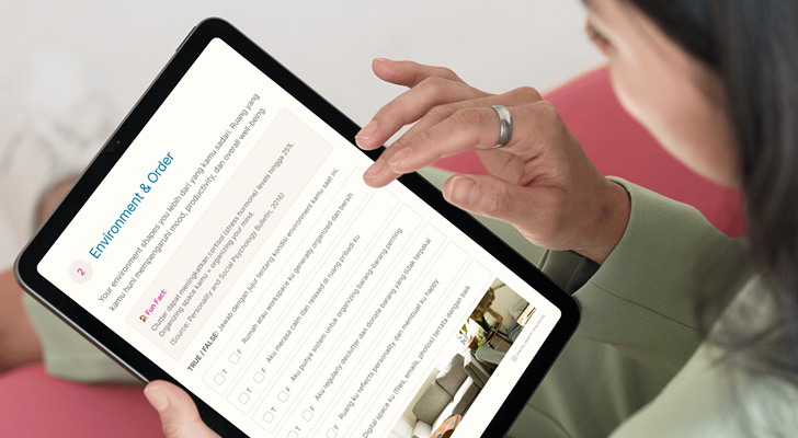 Person using a tablet to view a pastel-green “Present Moment Check-in” worksheet with highlighted Yes/No checkboxes and a hand touching water, seated on a pink sofa.